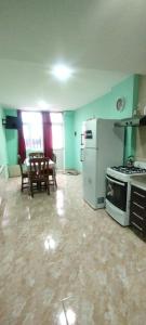 a kitchen with a stove and a table in it at Departamento Dulce Adelina I - Zona Céntrica in Río Grande