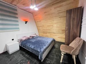 a bedroom with a bed and a chair at Rest House İsmayıllı A frame in İsmayıllı