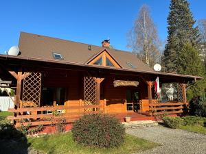 a large wooden cabin with a porch at Chatka Puchatka in Wisła