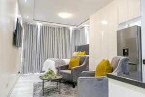 a living room with two chairs and a table at Millenium Heights Borrowdale in Harare