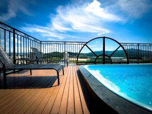 a balcony with a swimming pool and two chairs on a deck at Apto no coração de Brusque in Brusque
