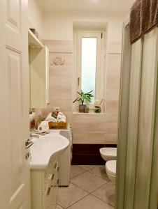 a bathroom with a sink and a toilet and a window at Lake Como PORTO VECCHIO - Charming Lakefront Apartment in the Heart of Domaso in Domaso +71 photos