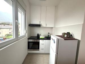 a kitchen with a white refrigerator and a window at Zenith Apartment - Herceg Novi & Beach & Private Parking in Bijela