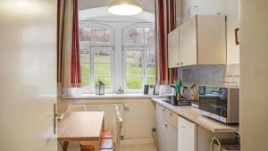 a kitchen with a table and a large window at Apartment am Nationalpark Sächsische Schweiz in Sebnitz