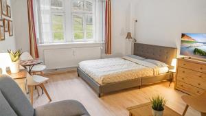 a bedroom with a bed and a living room at Apartment am Nationalpark Sächsische Schweiz in Sebnitz
