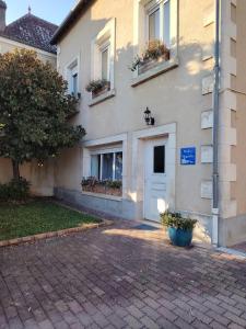 a building with a white door and windows and a courtyard at Studio Magnolia in Saint-Satur