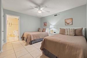 a bedroom with two beds and a ceiling fan at Barefoot Getaway in Orange Beach