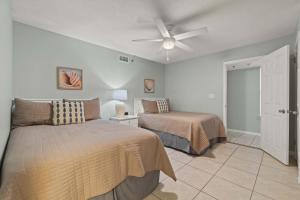 a bedroom with two beds and a ceiling fan at Barefoot Getaway in Orange Beach