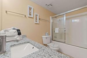 a bathroom with a sink and a toilet and a shower at Barefoot Getaway in Orange Beach