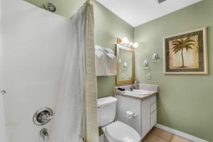 a bathroom with a toilet and a sink and a shower at Sunsets and Palms in Gulf Shores