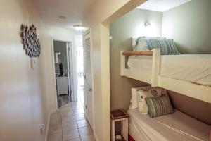 a bedroom with two bunk beds and a hallway at Sunsets and Palms in Gulf Shores