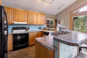 a kitchen with wooden cabinets and a black refrigerator at Happy Jack in Rapid City