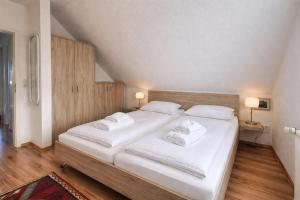 a bedroom with a large bed with white sheets and towels at Ferienhaus Klüver in Kühlungsborn