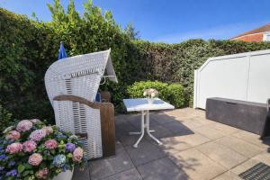a patio with a table and chairs and flowers at Ferienhaus Klüver in Kühlungsborn +1 photo