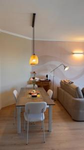 a dining room with a table and a couch at NB Luxury Attico Vista Mare in Sanremo
