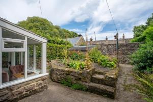 a stone house with a window and a garden at 1 Bed in Elton oc-dctco in Elton