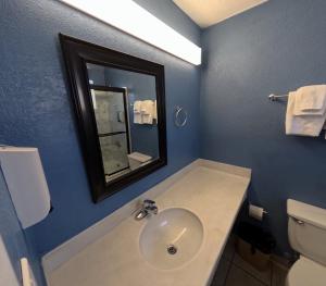 a bathroom with a sink and a mirror and a toilet at Heritage Inn - Milpitas in Milpitas +17 photos