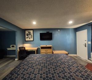 a bedroom with a bed and a desk and a tv at Heritage Inn - Milpitas in Milpitas