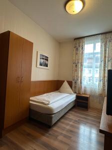 a small bedroom with a bed and a window at Hotel Löwen in Blaubeuren