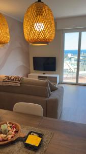 a living room with a couch and a table at NB Luxury Attico Vista Mare in Sanremo