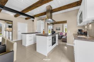 a kitchen with white cabinets and a ceiling with exposed beams at Ferienwohnung Lille Hus 1 St Peter-Ording in Böhl