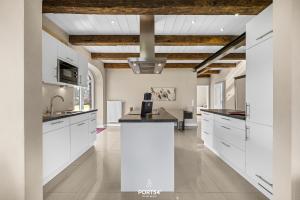 a kitchen with white cabinets and a ceiling at Ferienwohnung Lille Hus 1 St Peter-Ording in Böhl