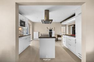 a kitchen with white cabinets and a large island at Ferienwohnung Lille Hus 2 St Peter-Ording in Böhl +29 photos