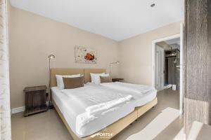 a bedroom with a large bed with white sheets at Ferienwohnung Lille Hus 2 St Peter-Ording in Böhl