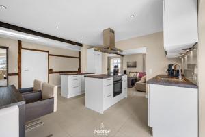 a kitchen with white cabinets and a living room at Ferienwohnung Lille Hus 2 St Peter-Ording in Böhl