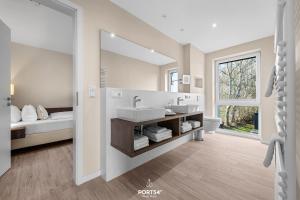 a bathroom with two sinks and a large mirror at Ferienwohnung Lille Hus 3 St Peter-Ording in Böhl
