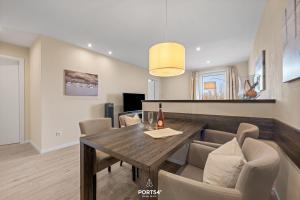 a dining room with a wooden table and chairs at Ferienwohnung Lille Hus 3 St Peter-Ording in Böhl