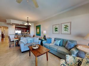 a living room with blue couches and a table at Adagio #402D in Santa Rosa Beach