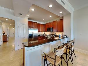 a kitchen with a large island with bar chairs at Adagio #402D in Santa Rosa Beach