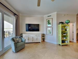 a living room with a television and a chair at Adagio #402D in Santa Rosa Beach