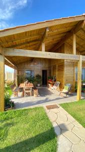 a wooden pavilion with a table and chairs at Chalé beira mar in Prado