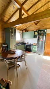 a kitchen with a table and a refrigerator at Chalé beira mar in Prado