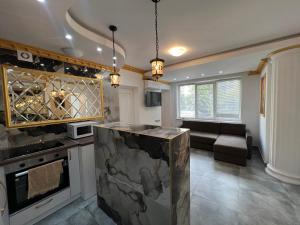 a kitchen with a stove and a couch in a room at Columna Central Park Apt in Chişinău