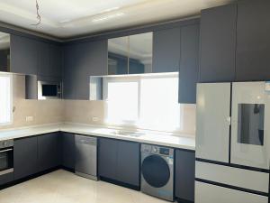 a large kitchen with blue cabinets and appliances at Ocean Gem in Bakau