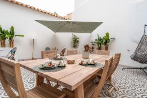 a wooden table with chairs and an umbrella at Casa Butterfly in Faro