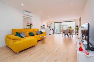 a living room with a yellow couch and a television at Casa Butterfly in Faro