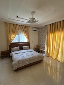 a bedroom with a bed and a large window at Ocean Gem in Bakau