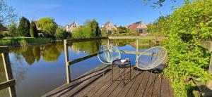 two chairs sitting on a dock next to a body of water at Kustverhuur, Park Scheldeveste, Zwin 022 in Breskens