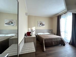 a bedroom with two beds and a mirror at Affittacamere In Centro in Tortolì