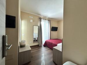 a hotel room with a red bed and a window at Affittacamere In Centro in Tortolì