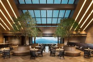 a restaurant with tables and chairs and a large glass ceiling at Conrad Hangzhou Tonglu in Yinzhu