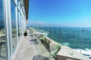 a balcony with tables and chairs and the ocean at Hampton By Hilton Antofagasta in Antofagasta