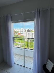 a room with a window with a view of a city at Apartamento com varanda in Lavras