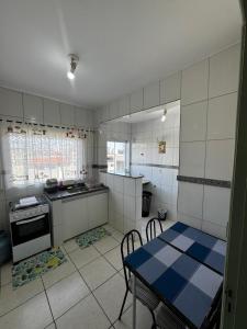 a kitchen with a table and a blue and white kitchen at Apartamento com varanda in Lavras