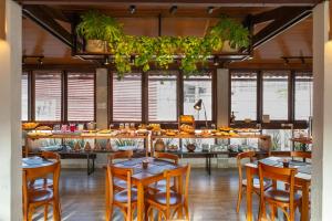 a restaurant with tables and chairs and plants at Pousada Jangadeiro in Porto Seguro