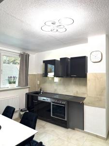 a kitchen with a black counter and a table at MIO Apartments Sulzbach in Schnappach +15 photos